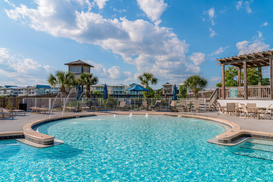 DESTIN, FLORIDA - CIRCA MAY, 2022: Private pool at Destin Pointe by Vacasa. Relaxing pool with clean and clear water against vacation rental houses and blue sky on a sunny day.