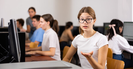 Fototapeta premium Friendly schoolgirl invites to the computer class of the school