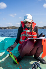 Equipped marine biologist writing notes on a paper while working