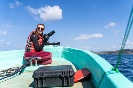 Happy marine biologist working while talking photo on a boat