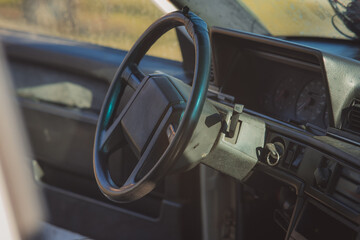 Old and worn steering wheel of an older car. Rectangular shape of steering wheel centre, plastic...