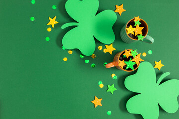 Saint Patricks Day composition, party background. Holiday decoration for St. Patrick's day, mug, green paper clover leaf, confetti on green background. Flat lay, top view, copy space