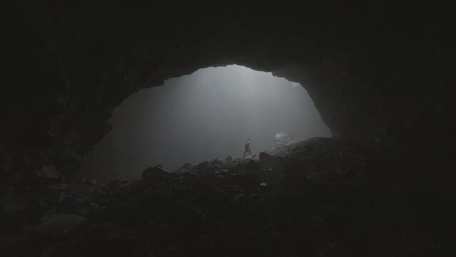 Silhouette Of Woman Dancing While Bird Flying In Famous Tranquil Cave - Java, Indonesia