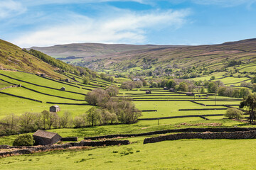 A view down the valley overlooking Thwaite in Swaledale in the Yorkshire Dales, with Kisdon Fell and on the left and Muker Common on the right.