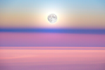 Moonrise above the shadow of the earth in pink morning sky