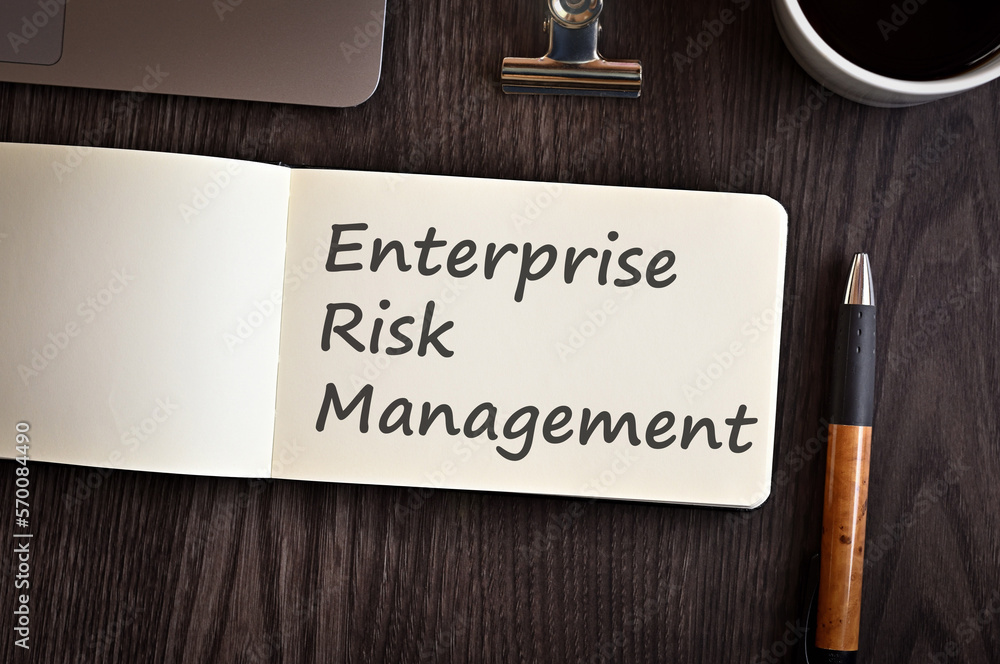 Poster there is notebook with the word enterprise risk management. it is an eye-catching image.