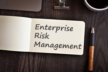 There is notebook with the word Enterprise Risk Management. It is an eye-catching image.