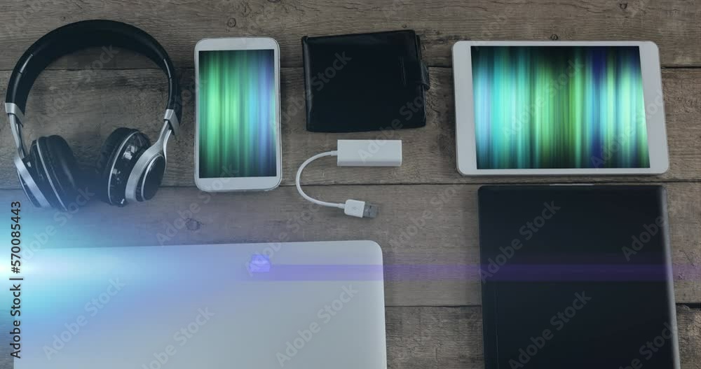 Aufkleber animation of light trails over technological devices with colorful moving shapes on screen on desk