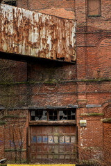 Fototapeta na wymiar old broken factory windows and bay door with brickwork on abandoned warehouse,
