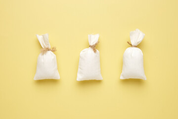 Flatlay picture of three flour bag on yellow background. Food supply issue concept.