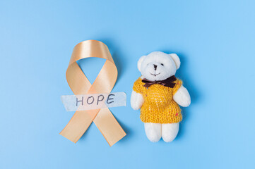Yellow ribbons with teddy bear toy on a blue background.