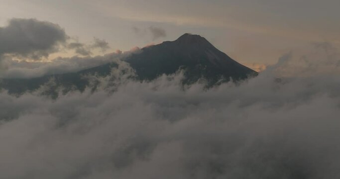 Aerial Slow Motion Shot Of Volcanic Mt Semeru At Sunset, Drone Flying Forward Over White Clouds - Java, Indonesia