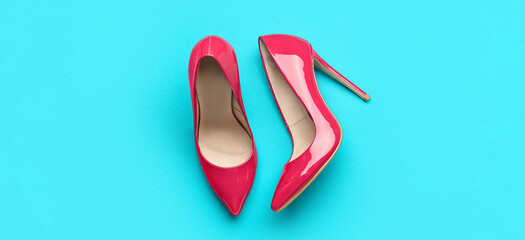 Stylish pink high heeled shoes on color background