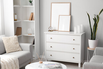 Interior of light living room with drawers, sofas and shelving unit