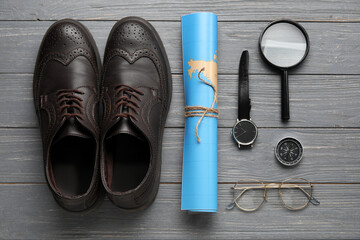 Compass with traveler accessories on grey wooden background