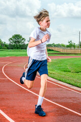 Male youth track runner racing at top speed