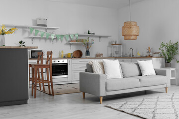 Interior of kitchen with Easter decor, counters and sofa