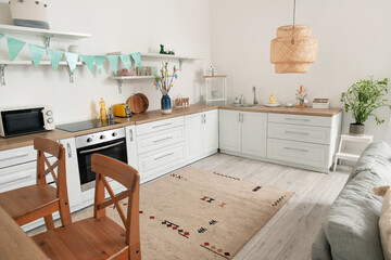 Interior of kitchen with Easter decor, white counters and shelves