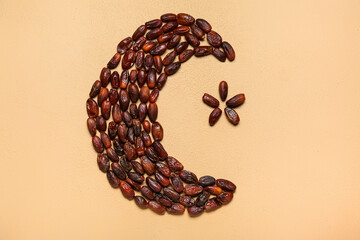 Crescent with star made of dried dates for Ramadan on beige background
