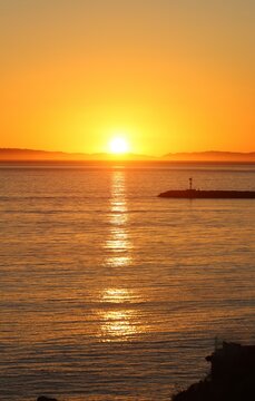 Sun shining over the sea at sunset. Catalina Island view from Orange county Coast. Coastal Sunset. Lighthouse vibes. Exotic location sunset wallpaper for travel, web design, beautiful vacation.