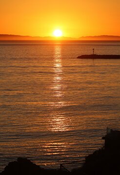 Sun shining bright in orange county. Vertical sunset image. Island off the pacific coast, coastal region. Beaches and sunny destinations for vacation. Traveling across California.