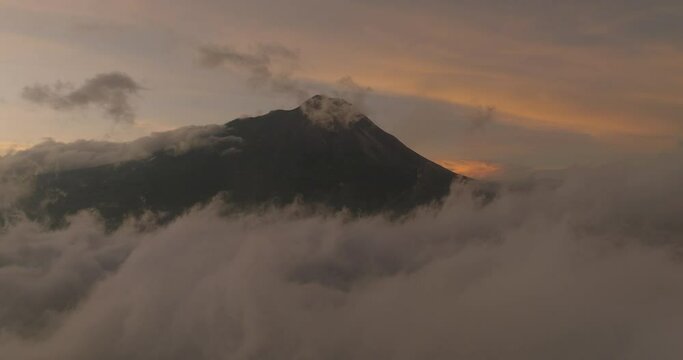 Aerial Slow Motion Scenic View Of Mt Semeru Peak Amidst Fluffy Clouds, Drone Flying Backwards During Sunset - Java, Indonesia