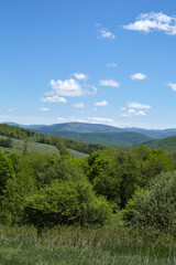 Landscape photograph with green rolling hills and blue sky. Summer scene.