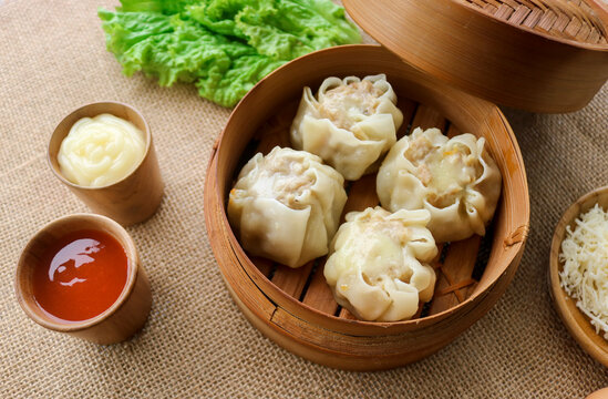 Photo of dimsum filled with hot and delicious mozzarella with chili sauce and mayonnaise, dimsum in a bamboo steamer just cooked.