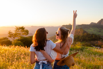 Female friends hugging and enjoying the sunset. Friendship and happiness concept.