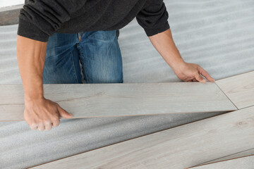 Worker installing new laminate flooring in room, closeup