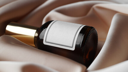 Luxury bottle of perfume on beige silk, closeup