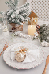 Festive place setting with beautiful dishware, cutlery and decor for Christmas dinner on white wooden table