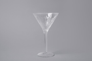 Empty clean martini glass on grey background