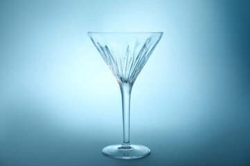 Elegant empty martini glass on light blue background