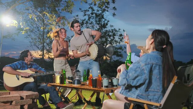 Group of diverse friend having outdoors camping party together in tent