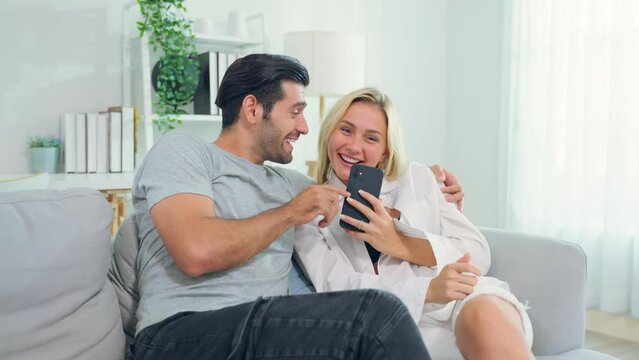 Caucasian young couple spend free leisure time together in living room