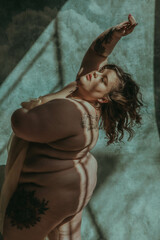 Naklejka premium fat white woman with back to the sun reaching up