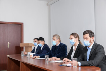 Business conference. People with protective masks working at table in meeting room