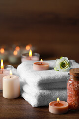 Beautiful spa composition with burning candles and flower on wooden table