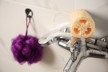 Purple shower puff and loofah sponge in bathroom, closeup