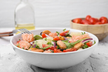 Delicious pomelo salad with tomatoes and mussels on white textured table, closeup