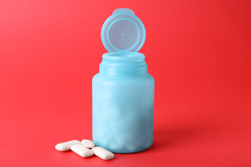 Jar with chewing gums on red background