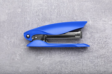 New bright stapler on grey table, top view. School stationery