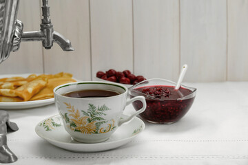 Cup of aromatic tea and treats on table. Space for text