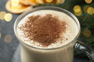 Glass cup of delicious eggnog with cinnamon, closeup