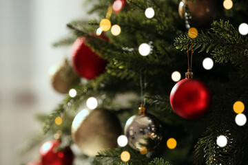Fototapeta na wymiar Christmas tree with beautiful baubles on blurred background, closeup. Space for text