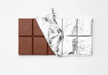 Tasty chocolate bar on white background, top view