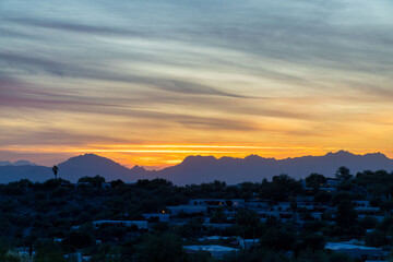 Late evening sunset with rolling hills and houses and palm trees on the ridge in the sonora desert of arizona wilderness