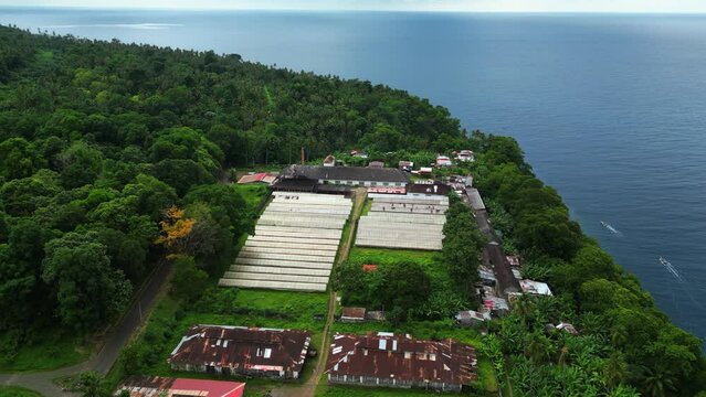 Aerial view tilting towards cocoa dryers at Roça Diogo Vaz, in sunny Sao Tome, Africa