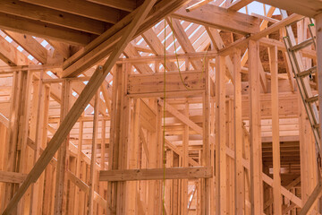 Fototapeta na wymiar As part construction newly constructed stick house wooden roof rafter timber beams which will be supported by truss frames